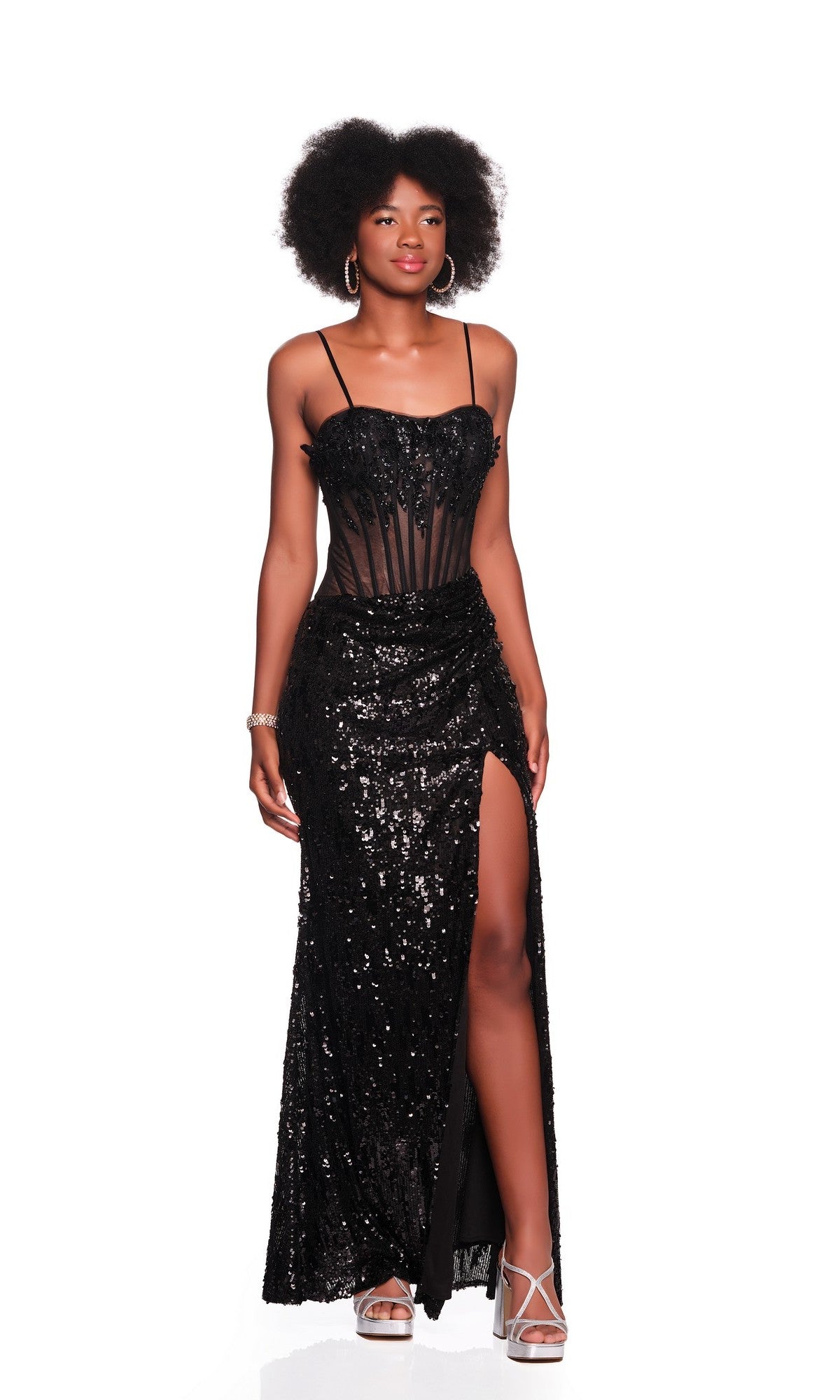 A woman wears the Dave and Johnny 12855 long prom dress with sequins, corset bodice, spaghetti straps, and high-leg slit, styled with silver hoop earrings and platform heels, standing against a white background.